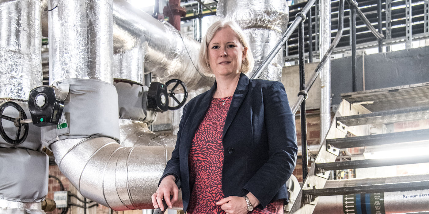 Prof. Catherine Noakes OBE beside plant room ventilation ductwork