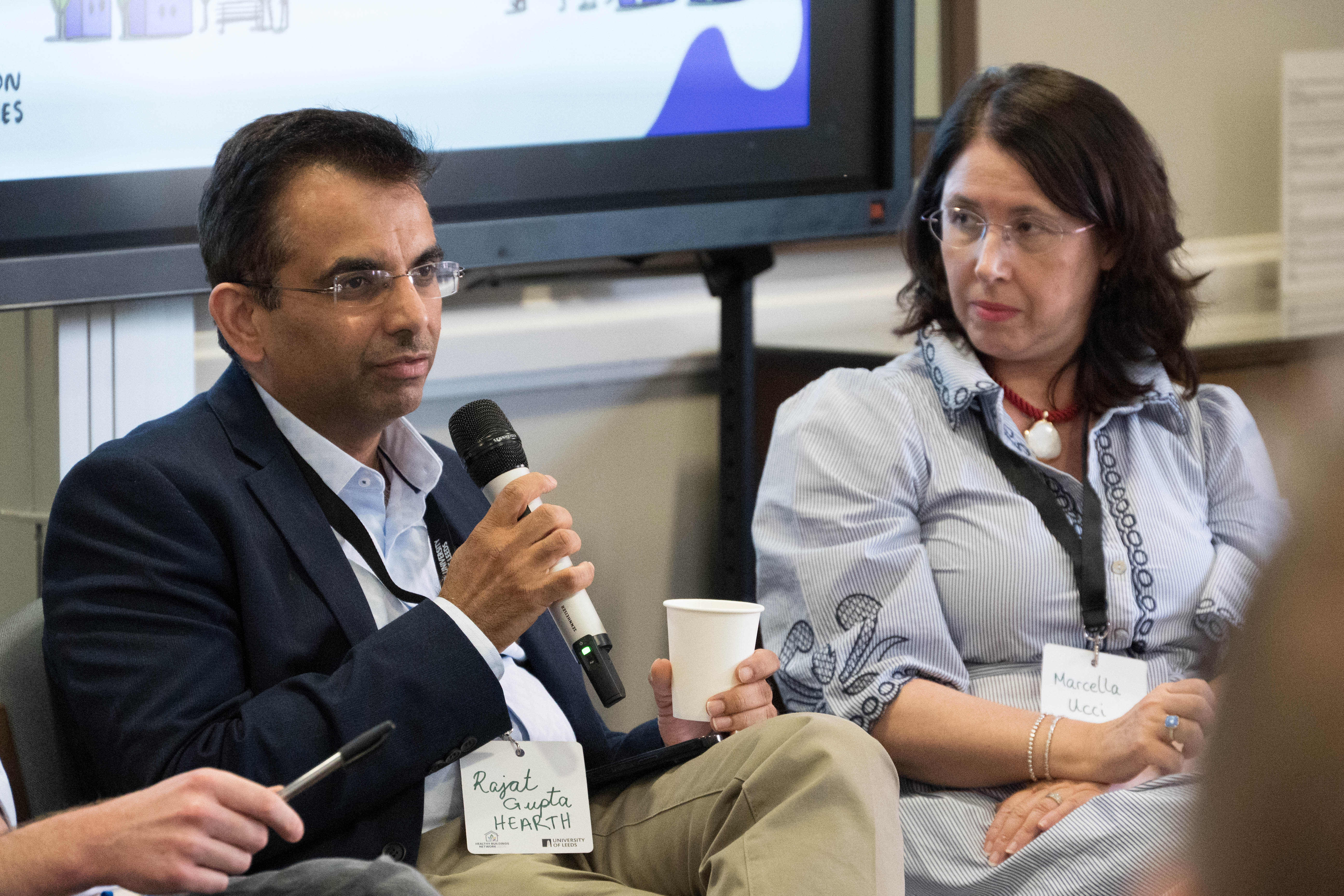 Rajat Gupta speaking at mic, Marcella Ucci listening — HBN Showcase 2026