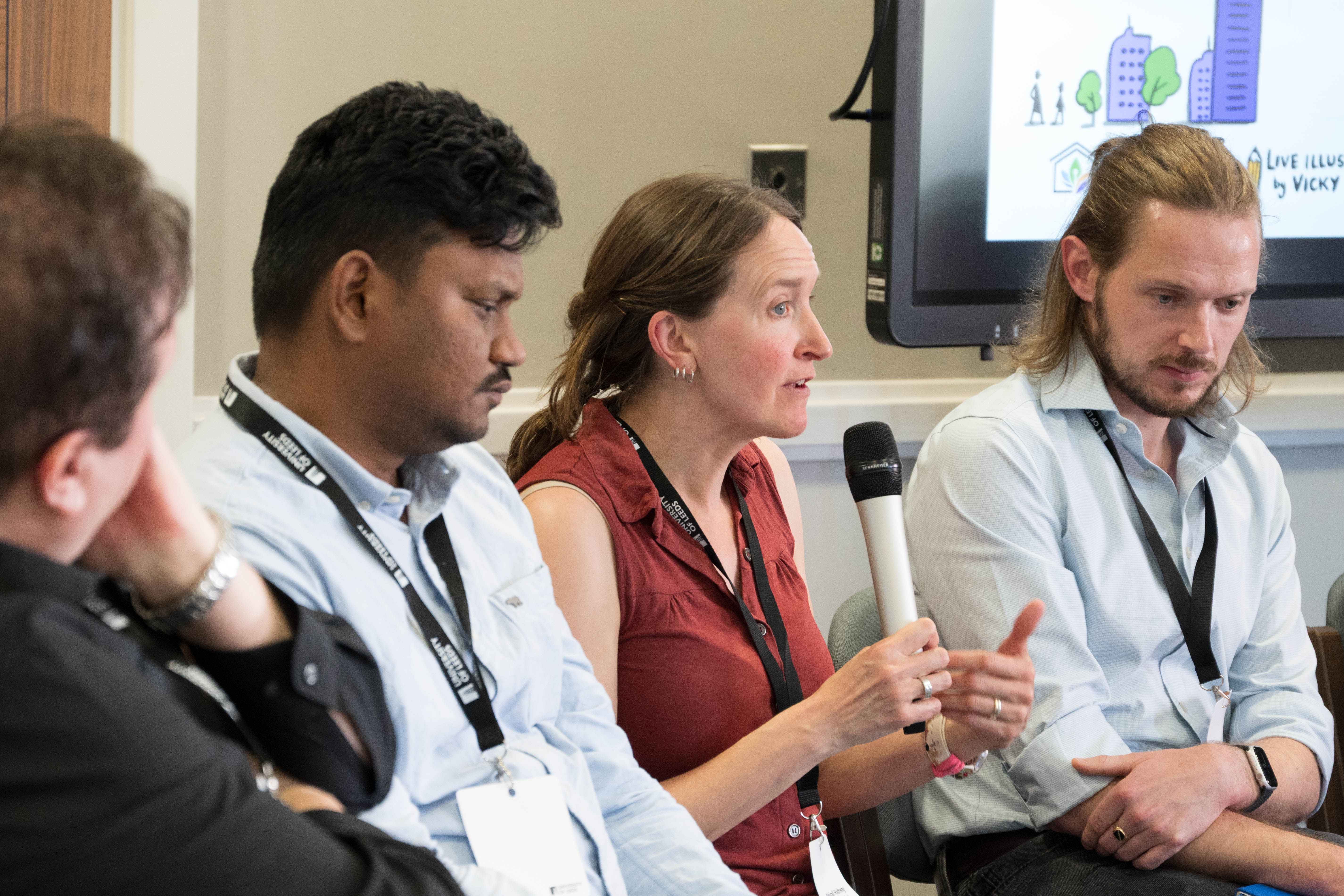 Abigail Hathway speaking at the panel — Akash Biswal and Doug Booker listening